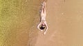 Aerial top view of young woman in bikini relaxing on sand tropical beach by sea and waves from above, girl on island beach Royalty Free Stock Photo