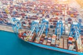 Aerial tope view - heavy huge ship with a lot of containers moored at the pier in the port, loading with cranes in the industrial