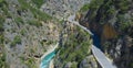 AERIAL: Tourist car cruises along the scenic mountain road running above a river