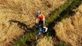 Aerial tracking shot a cyclist riding along the rural field path