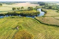 An aerial of a tractor cutting grass on a meadow next to a river Royalty Free Stock Photo