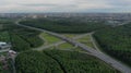 AERIAL. Traffic interchange. Top view of the road, city and forest. Summer video from the drone. Royalty Free Stock Photo