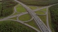 AERIAL. Traffic interchange. Top view of the road, city and forest. Summer video from the drone. Royalty Free Stock Photo