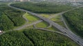 AERIAL. Traffic interchange. Top view of the road, city and forest. Summer video from the drone. Royalty Free Stock Photo