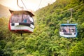 Aerial tramway moving up in tropical jungle mountains