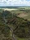 Aerial of an transmission towers running along a river gorge and undeveloped farmland in Dasmarinas Cavite