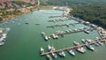 Aerial travelling shot of Mediterranean marina piers and anchored boats and yachts on a sunny summer day