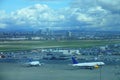 AERIAL: Two large passenger airplanes taxi close to the airport parking lot. Royalty Free Stock Photo