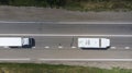 Aerial. Two little trucks driving by the highway. Top view Royalty Free Stock Photo