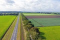 Aerial from a typical dutch landscape: straight roads, windmills and beautiful meadows in the Netherlands