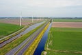 Aerial from a typical dutch landscape: Wind turbines, canals, straight roads and flat meadows in the Netherlands