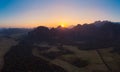 Aerial: Vang Vieng backpacker travel destination in Laos, Asia. Sunset over scenic cliffs and rock pinnacles, rice paddies valley