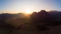 Aerial: Vang Vieng backpacker travel destination in Laos, Asia. Sunset over scenic cliffs and rock pinnacles, rice paddies valley