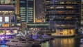 Aerial vew of Dubai Marina with shoping mall, restaurants, towers and yachts night timelapse, United Arab Emirates.