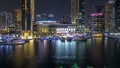 Aerial vew of Dubai Marina with shoping mall, restaurants, towers and yachts night timelapse, United Arab Emirates.