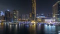 Aerial vew of Dubai Marina with shoping mall, restaurants, towers and yachts night timelapse, United Arab Emirates.
