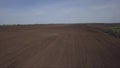 Aerial video of big tractor with cultivator ploughs field