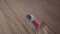 Aerial video of big tractor with cultivator ploughs field