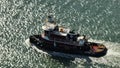 Aerial video of a tug boat on glimmering water