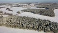 Aerial video view of a winter landscape in Europe, flying over small forests toward a small village