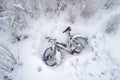 aerial view of abandoned bicycle half-buried in snow