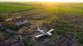 Aerial view of abandoned broken plane in a field during sunset