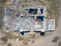 Aerial view of the abandoned and destroyed building with a large number broken bricks from the roofless walls with rubbish and Royalty Free Stock Photo