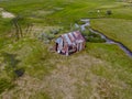 Aerial view of abandoned little small wooden house in the green valley of a mountain