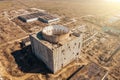 Aerial view of abandoned and ruined Nuclear Power Plant. Huge building with round whole for reactor in roof without celling