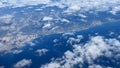 Aerial view above clouds from airplane window with blue sky. Portogal land view from above. Royalty Free Stock Photo