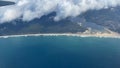 Aerial view above clouds from airplane window with blue sky. Portogal land view from above. Royalty Free Stock Photo