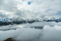 Aerial view above the clouds in snow mountain peaks Royalty Free Stock Photo