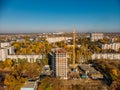 Aerial view from above, construction of modern house or building with crane and other industrial vehicles among city landscape Royalty Free Stock Photo