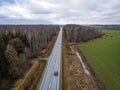 Aerial view from above of country road through the forest in spring morning Royalty Free Stock Photo