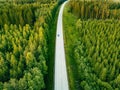 Aerial view from above of country road through the green summer forest in summer Finland. Royalty Free Stock Photo