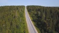 Aerial view from above of country road through the green summer forest in summer. Shot. Car driving. High angle view of Royalty Free Stock Photo