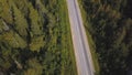 Aerial view from above of country road through the green summer forest in summer. Shot. Car driving. High angle view of Royalty Free Stock Photo