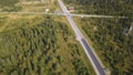 Aerial view from above of country road through the green summer forest in summer. Shot. Car driving. High angle view of Royalty Free Stock Photo