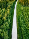 Aerial view from above of country road through the green summer forest in summer Finland. Royalty Free Stock Photo