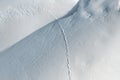 aerial view from above of fresh snow surface texture with snowdrifts and wild animal foot traces on bright cold winter day. Fox,