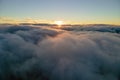 Aerial view from above at high altitude of dense puffy cumulus clouds flying in evening. Amazing sunset from airplane Royalty Free Stock Photo