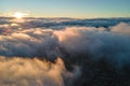 Aerial view from above at high altitude of dense puffy cumulus clouds flying in evening. Amazing sunset from airplane Royalty Free Stock Photo