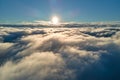 Aerial view from above at high altitude of dense puffy cumulus clouds flying in evening. Amazing sunset from airplane Royalty Free Stock Photo