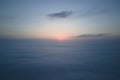 Aerial view from above at high altitude of dense puffy cumulus clouds flying in evening. Amazing sunset from airplane Royalty Free Stock Photo