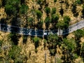 Aerial view from above of a rural landscape with a curvy road and white car in Italy Royalty Free Stock Photo