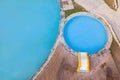 Aerial view from above of a small children`s pool with blue water next to a bouncy slide with wooden sunbeds and grass on a summe Royalty Free Stock Photo