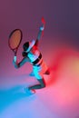 Aerial view of active professional tennis player serving over gradient pink-purple background in neon light. Sport