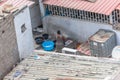 Aerial view of a african mother washing clothes in exterior patio on poor neighborhood in the central area of Luanda city