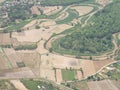 Aerial view of agricultural fields, river, mountains, and land have seen through the airplane window