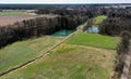 Aerial view of an agricultural meadow with two rectangular fish ponds and dark trees